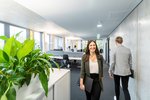 Frau mit Laptop  Eine Frau läuft mit einem Laptop in der Hand durchs Büro