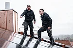 Elektroinstallateure auf einem Dach bei der Montage einer PV-Anlage